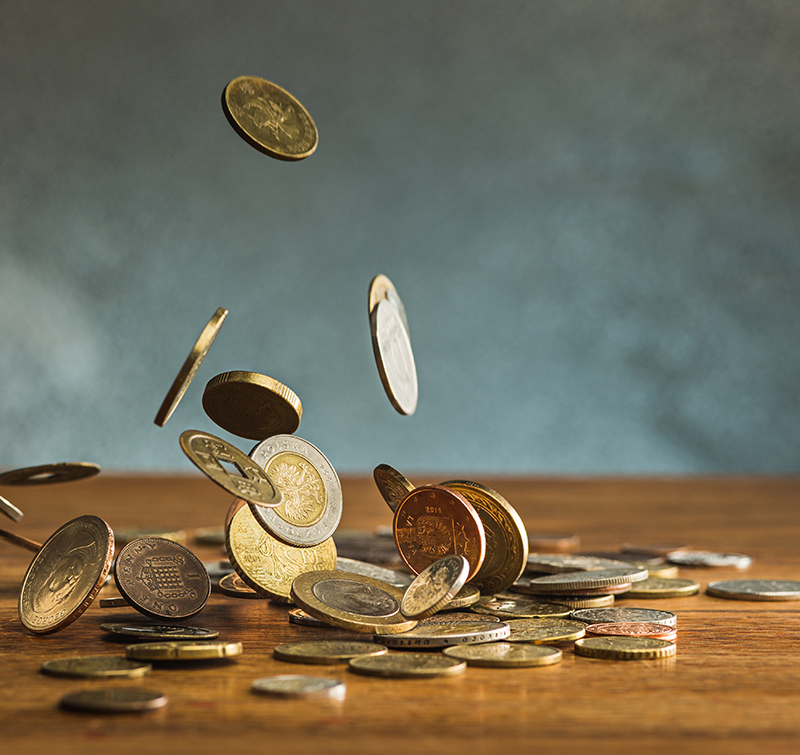 The silver and golden coins and falling coins on wooden background